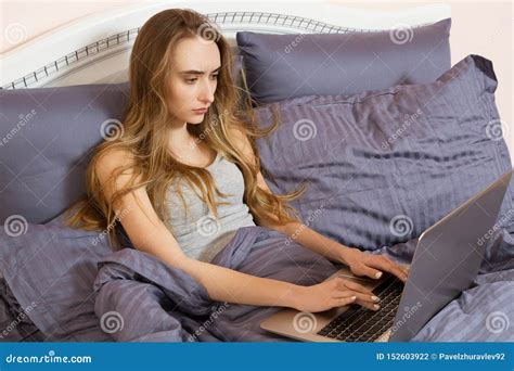 pretty teen woman using her laptop in bed beautiful girl in glasses working on laptop in