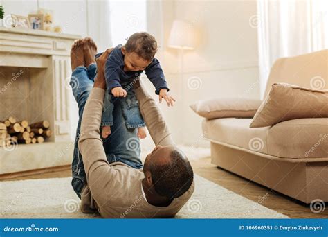 Cheerful Father Playing With His Young Son On The Floor Stock Image