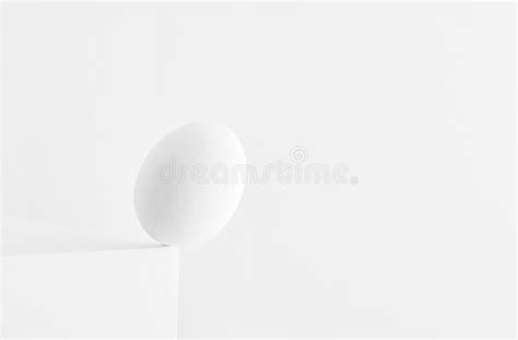 Egg Standing On The Edge Of A Table And Falling Down On White