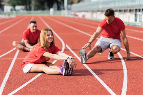 Group Of Runners Warming Up On Race Track Stock Photo Download Image