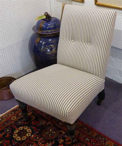 SLIPPER CHAIR, Victorian ebonised on turned supports and castors, newly