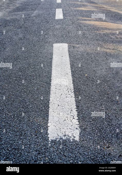 Broken White Lines Painted On The Middle Of A Tarmac Road Stock Photo