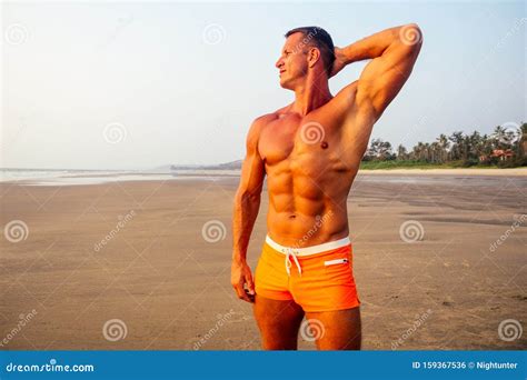 Young Handsome Man Applying Cream Sunscreen Lotion On The Sea Beach