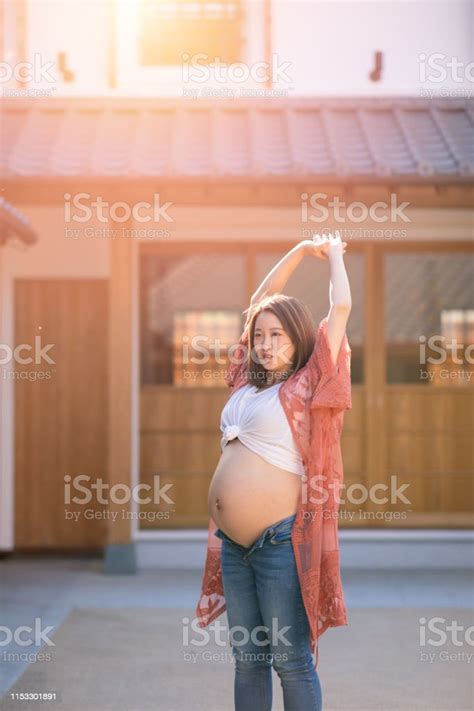 Pregnant Teenage Girl Deep Breathing In Traditional Japanese Town Stock