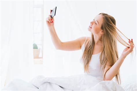 Free Photo Blonde Girl Taking Selfie On The Bed