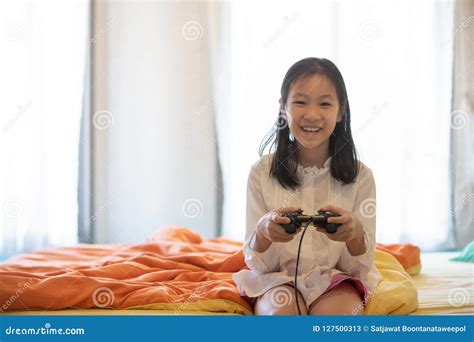 Asian Girl Playing Video Game On The Bed Stock Image Image Of Girl