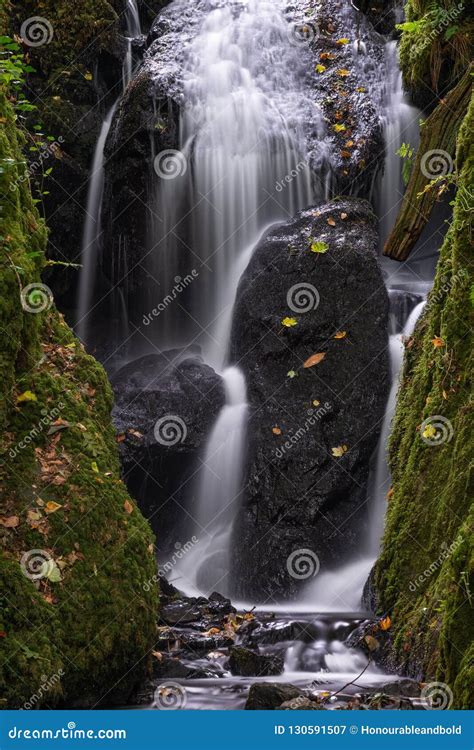 Beautiful Tall Waterfall Flowing Over Lush Green Landscape Foliage In