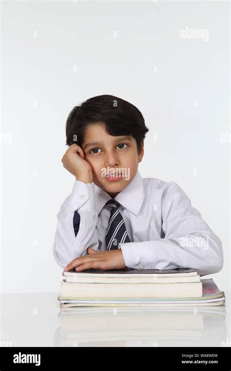 Schoolboy Sitting With Books In A Classroom Stock Photo Alamy