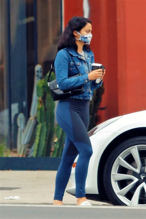 camila mendes shows off her toned legs in navy leggings while making a coffee run in her tesla
