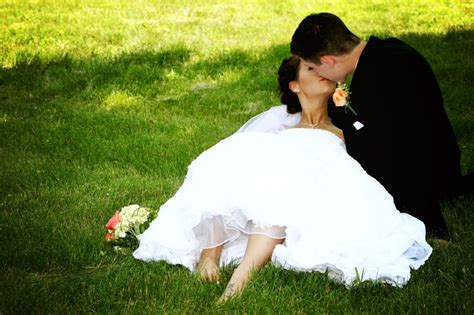 Bride And Groom Kissing Laying In The Grass