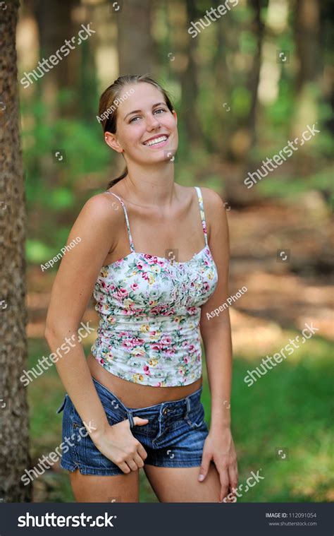 Beautiful Young Caucasian Woman In Tank Top And Denim Shorts Smiling In