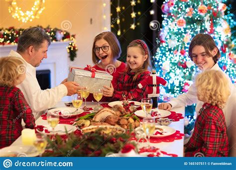 During christmas itself, wine or beer is served, as presents after dinner. Family With Kids Having Christmas Dinner At Tree Stock Image - Image of grandparents ...