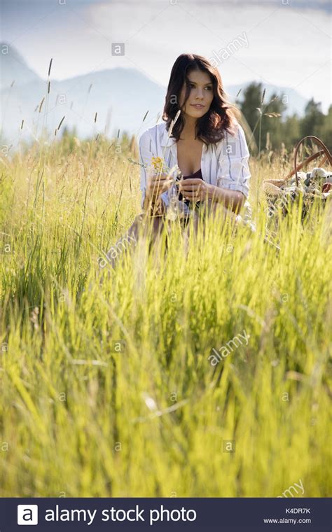 Brunette Woman Sitting In Tall Sunny Summer Rural Grass Stock Photo Alamy