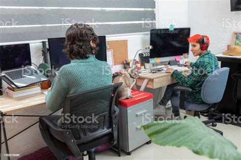 Latin Lesbian Couple Working On Their Computers At Their Desk At Home