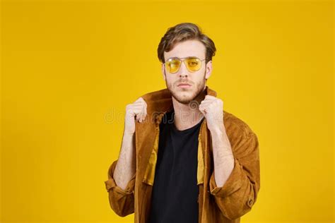 Guy With Yellow Sunglasses Posing On A Yellow Background Stock Image