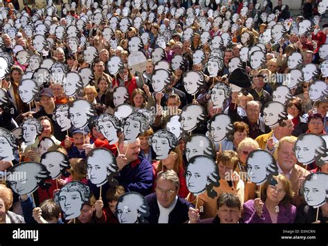 A Crowd Of People Present Masks Which Depict Wolfgang Amadeus Mozart