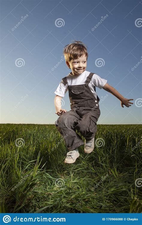 Boy Playing Jumping On Summer Sunset Meadow Stock Photo Image Of