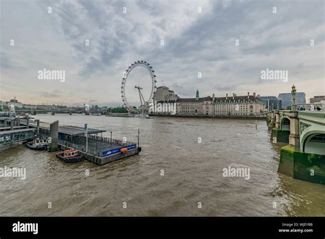 The London Eye And The Thames River On A Cloudy Day In London England