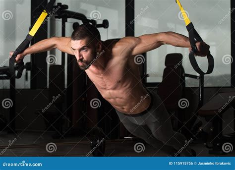 Young Attractive Man Training With Trx Fitness Straps Stock Photo