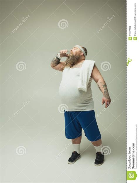 Tired Fat Man Drinking Water From Bottle After Sport Stock Photo