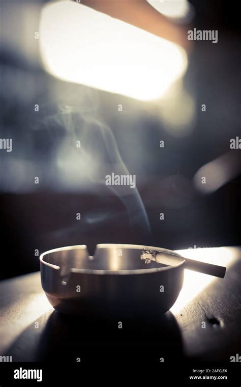 Close Up Shot Of A Burning Cigarette In An Ashtray With Smoke Rising