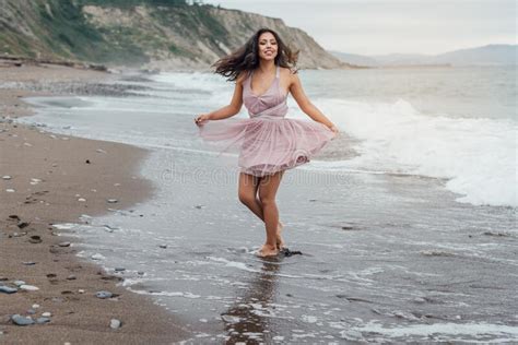 Joven Latina Corriendo A Lo Largo De La Playa Con Un Vestido Rosa Foto De Archivo Imagen De