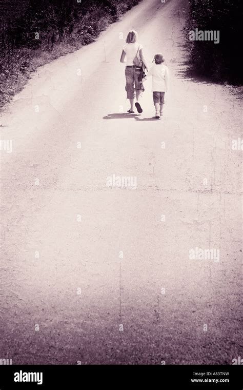 Mother And Daughter Walking Alone A Road Holding Hands Stock Photo Alamy