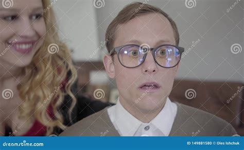 Blond Sensual Woman Suddenly Kissing The Cheek Of Modestly Dressed Man In Glasses The Nerd