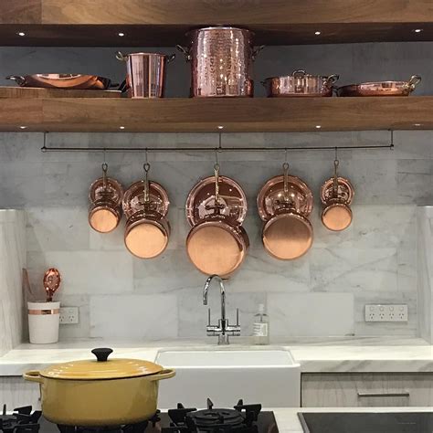 Pots And Pans Are Hanging On The Wall Above The Stove