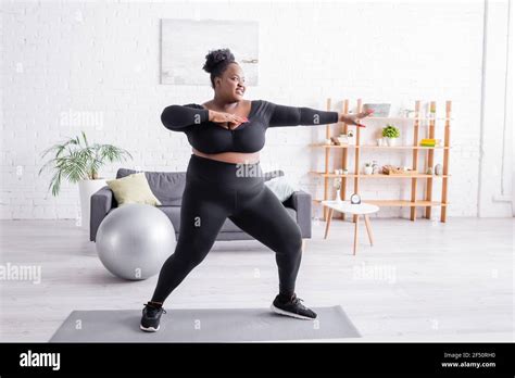 Full Length Of Pleased African American Plus Size Woman In Sportswear