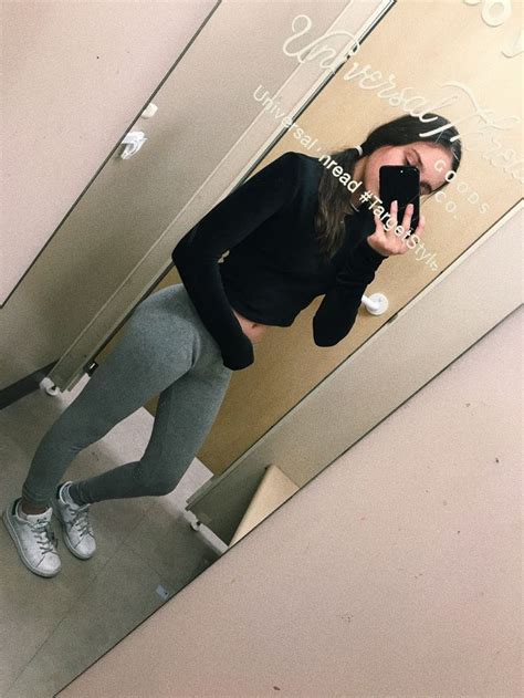 A Woman Taking A Selfie In Front Of A Mirror Wearing Leggings And Sneakers