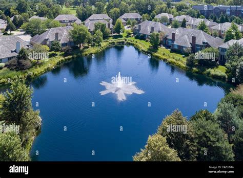 Aerial view of a luxury townhouse complex surrounded by a pond in a
