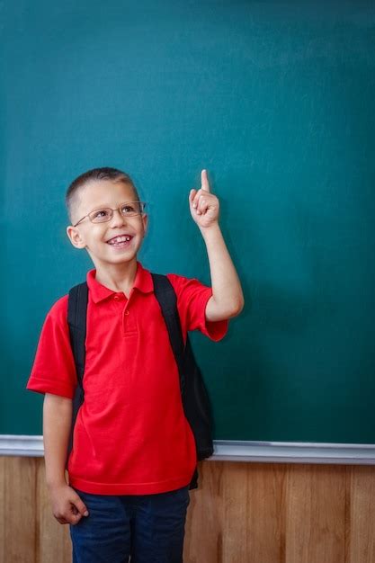 Premium Photo A Happy Child Child Standing At The Blackboard With A