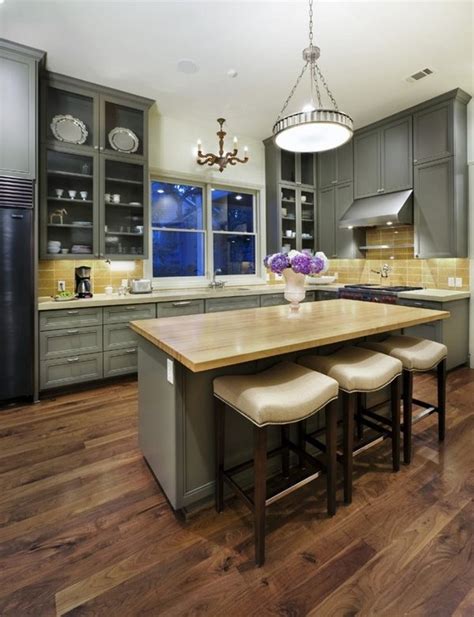 Mosaic floor tiles under the kitchen island and wooden floors around. Unfinished hardwood flooring with a seamless and natural ...
