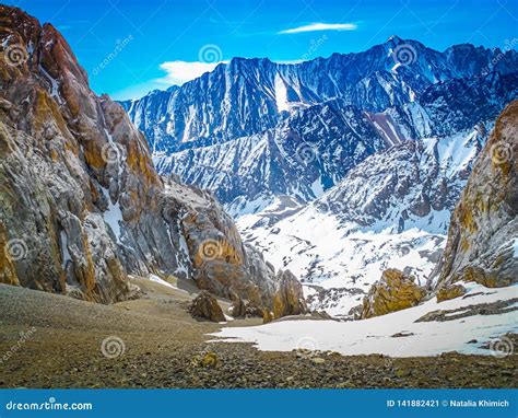 Snow Capped Mountain Peaks Against A Bright Blue Sky The Concept Of
