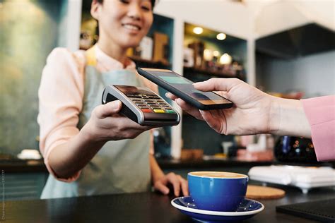 Customer Paying For Coffee With Phone by Clique Images
