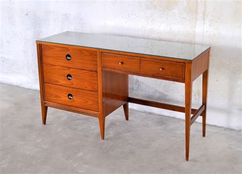 Its three drawers are accented with antique bronze hardware. SELECT MODERN: Mid Century Modern Desk / Vanity Table