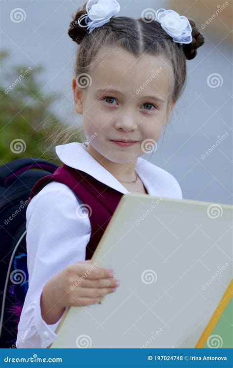 Adorable Little Schoolgirl Reading Book Outdoors On The School Yard