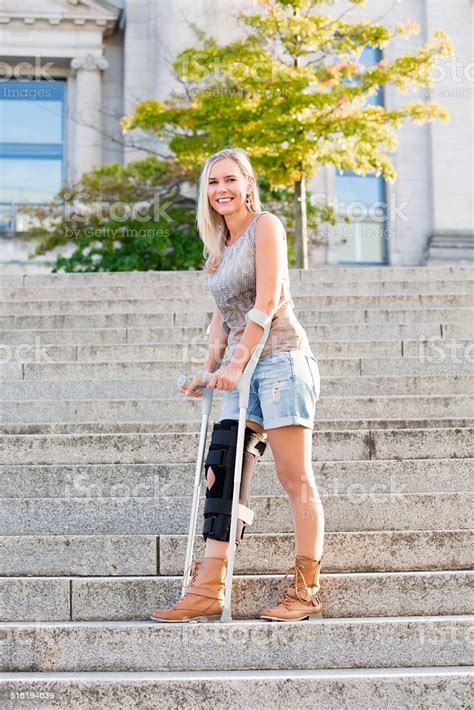 Blonde Woman With Crutches Stock Photo Download Image