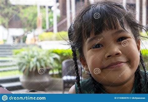 Closeup Portrait Of Adorable Little Asian Girl Smiling Happily Wearing Green Dress While