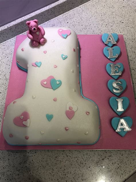 A Pink And Blue Birthday Cake With A Teddy Bear On Top