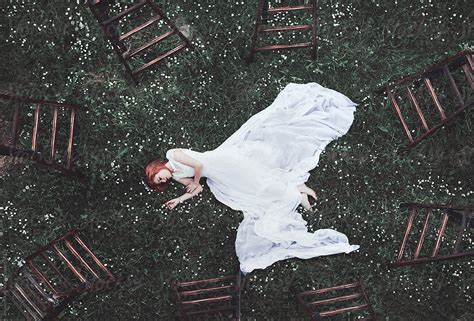 Young Woman Surrounded With Ladders Laying On Grass By Stocksy Contributor Jovana Rikalo