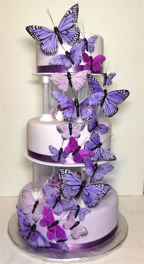 A Three Tiered Cake With Purple Butterflies On It
