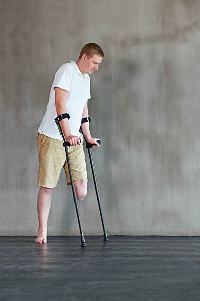 Handicapped One Legged Man Walking On Crutches Pictures Images And