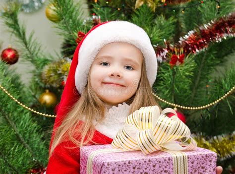 Little Girl In Santa Hat With Present Have A Christmas Stock Photo
