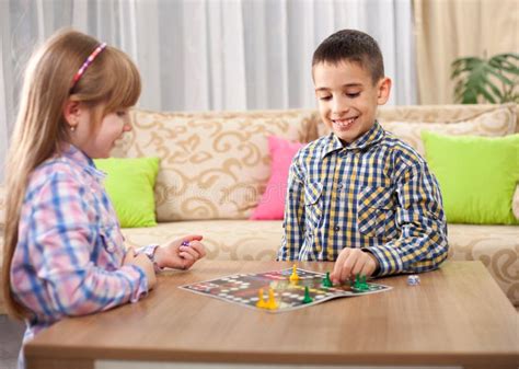 Children Playing Board Game Ludo At Home On The Table Stock Image