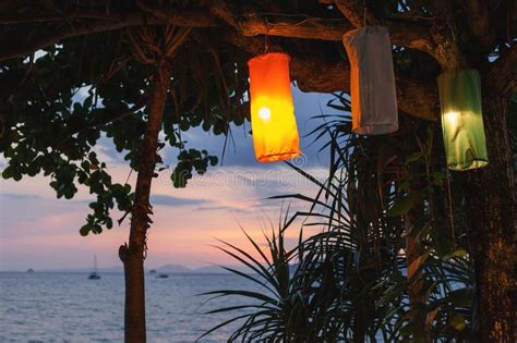 Sunset On An Island Beach With Lanterns Illuminating The Romantic Scene