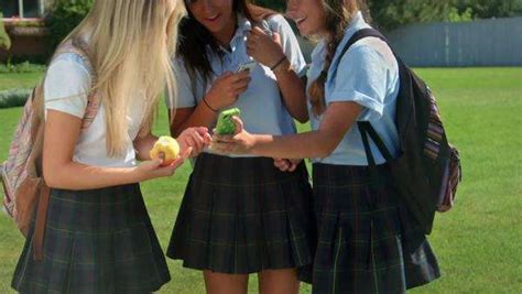 Three Pretty Uniformed Teen School Girls Standing Sitting And Chatting