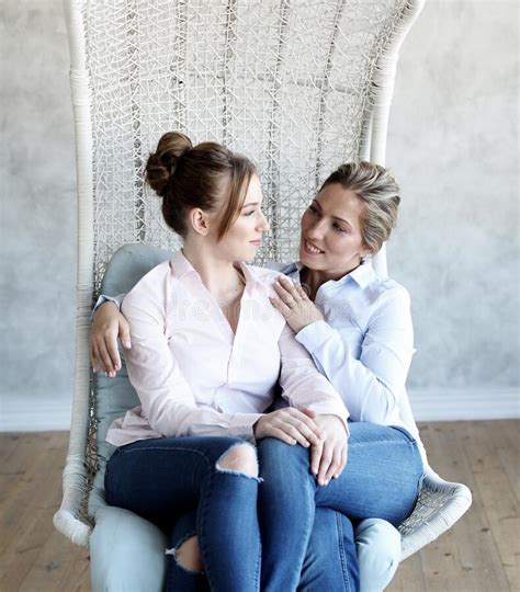 Mature Motherand Daughter Hugging Each Other In Armchair Stock Image