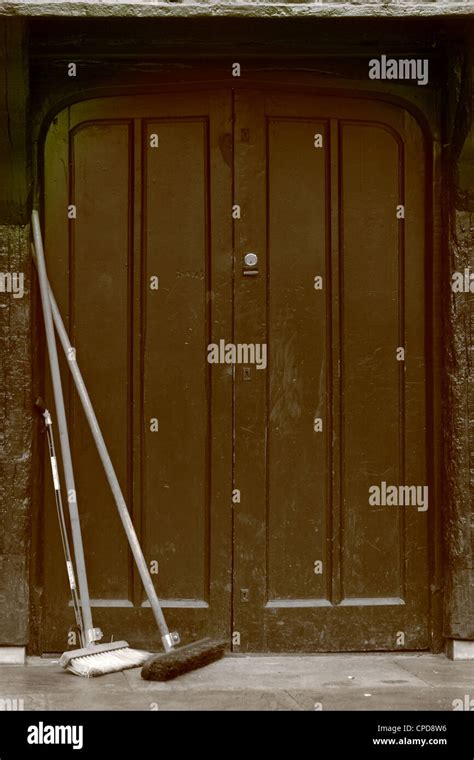Brooms Resting Against Old Wooden Doors Stock Photo Alamy